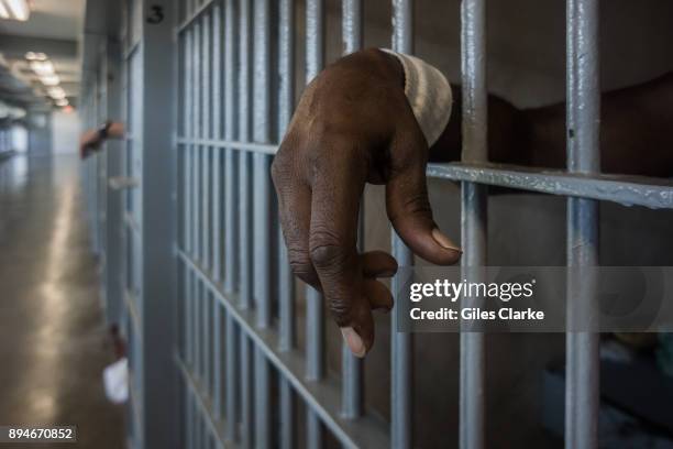 Prisoner's hands inside a punishment cell wing at Angola prison. The Louisiana State Penitentiary, also known as Angola, and nicknamed the "Alcatraz...