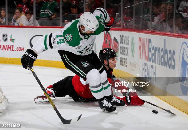 Jamie Benn of the Dallas Stars and Steven Santini of the New Jersey Devils fight for the puck in the first period on December 15, 2017 at Prudential...