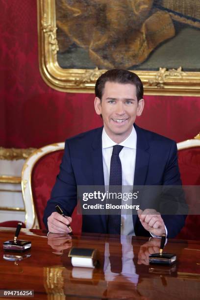 Sebastian Kurz, Austria's chancellor, poses for photographs as he signs a document during the inauguration of the new federal government in Vienna,...