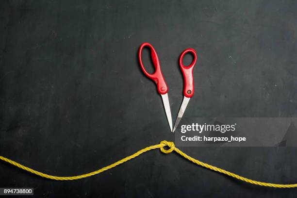 rope tied in a knot and broken scissors. - harpazo hope stock pictures, royalty-free photos & images