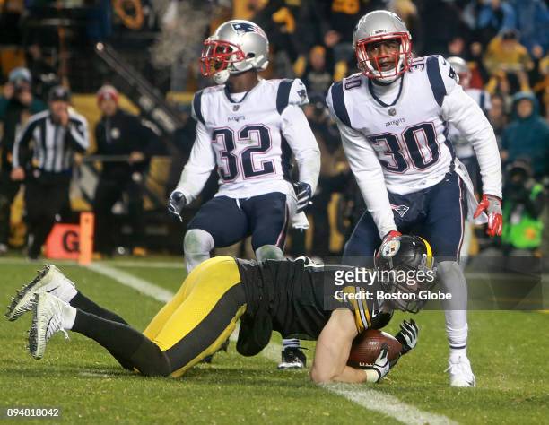 New England Patriots Devin McCourty and Duron Harmon look for a call after Pittsburgh Steelers tight end Jesse James, left, lunged over the goal line...