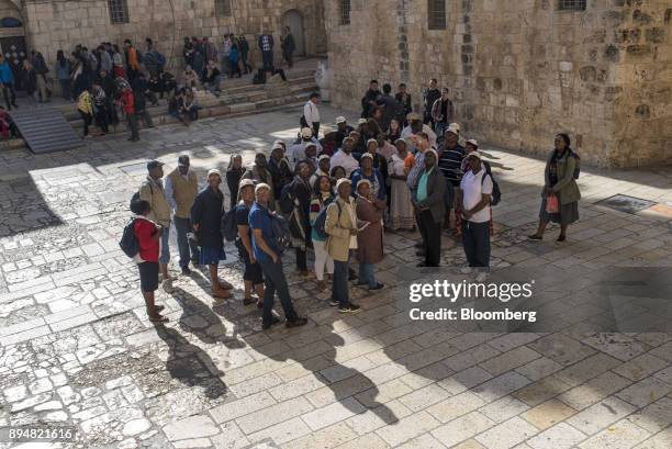 Tour group looks up towards the Church of the Holy Sepulchre in the Christian quarter of the Old City in Jerusalem, Israel, on Saturday, Dec. 16,...