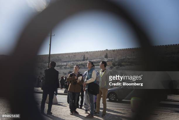 Tourists look up at the Church of all Nations outside the Old City in Jerusalem, Israel, on Saturday, Dec. 16, 2017. The United Nations Security...