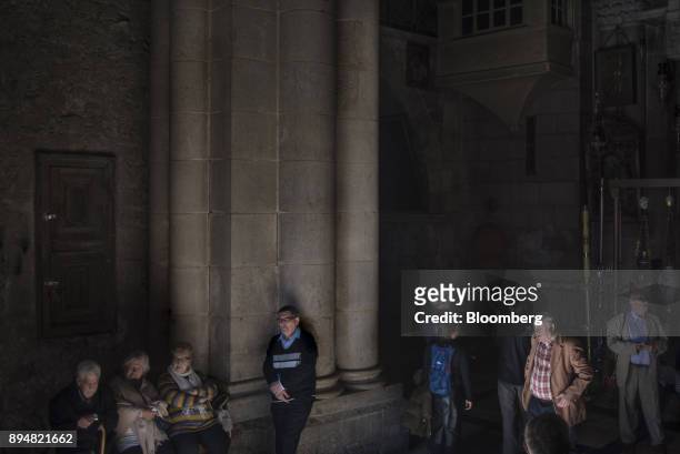 Visitors wait at the entrance of the Church of the Holy Sepulchre in the Christian quarter of the Old City in Jerusalem, Israel, on Sunday, Dec. 17,...