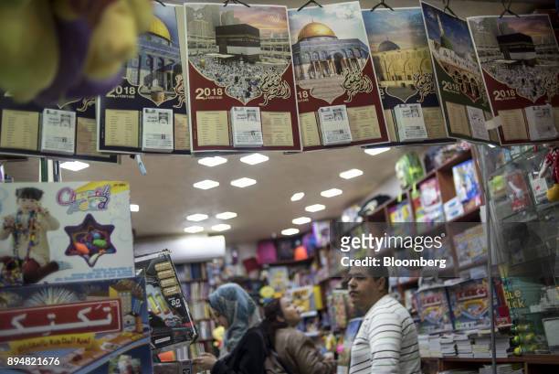 Customers browse items inside a store selling religious calendars in the Muslim quarter of the Old City in Jerusalem, Israel, on Saturday, Dec. 16,...