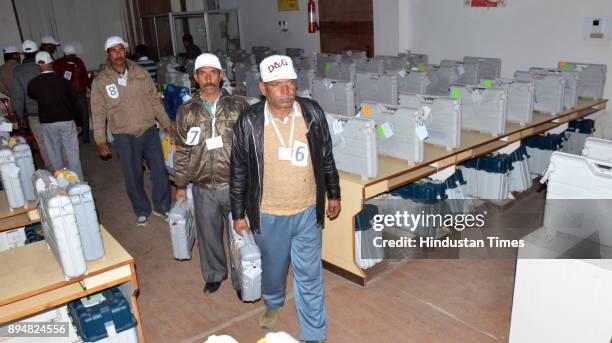 Election officials carry electronic voting machines as they arrive to count votes on December 18, 2017 in Dharamsala, India. In Himachal Pradesh...