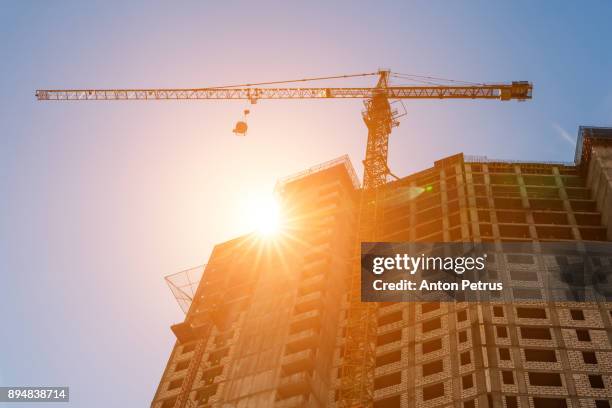 construction crane and the building against the sunset sky. - asia central fotografías e imágenes de stock