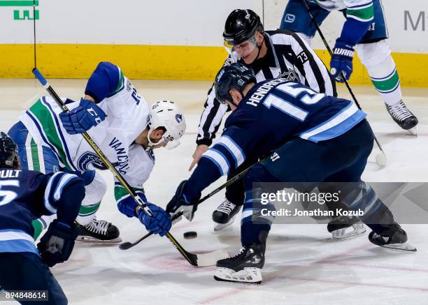 Michael Chaput of the Vancouver Canucks wins a third period face-off against Matt Hendricks of the Winnipeg Jets at the Bell MTS Place on December...