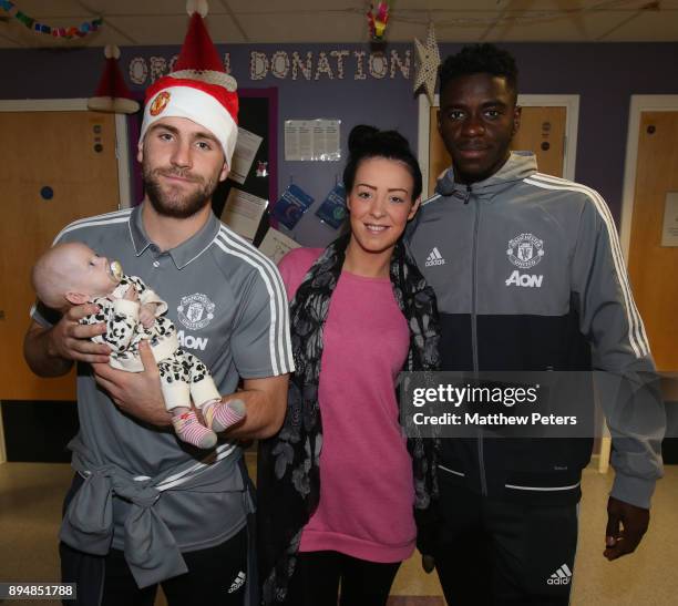 Luke Shaw and Axel Tuanzebe of Manchester United deliver Christmas presents to Athena-Reign, 3 months, during the club's annual Christmas hospital...