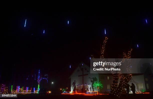 People walks around in front of a church lit up ahead of the Christmas Festival at Nagarjan Kuda village in Dimapur, India north eastern state of...