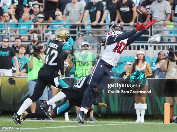 DeAndre Hopkins of the Houston Texans reaches for the football in front of Jalen Ramsey and Barry Church of the Jacksonville Jaguars during the...