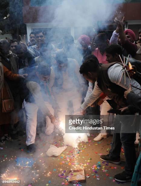 Supporters burn firecrackers to celebrate as their party wins in Gujarat and Himachal state assembly Election at party office on December 18, 2017 in...
