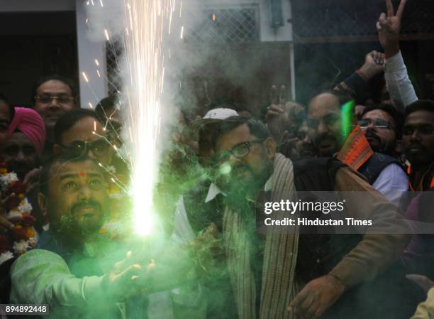 Supporters burn firecrackers to celebrate as their party wins in Gujarat and Himachal state assembly Election at party office on December 18, 2017 in...