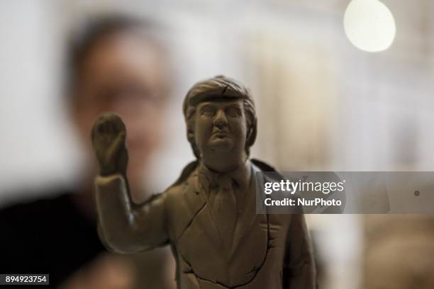 Giuseppina Erzingher works on a figurine Donald Trump in shop Ferrigno in 'Via San Gregorio Armeno' in Naples, Italy on December 18, 2017. Various...