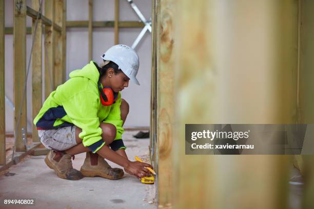 female worker using tape measure at site - constructs stock pictures, royalty-free photos & images