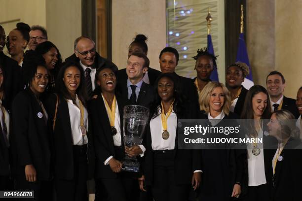 French President Emmanuel Macron and his wife Brigitte pose with members of the French womens handball team at The Elysee Palace in Paris on December...