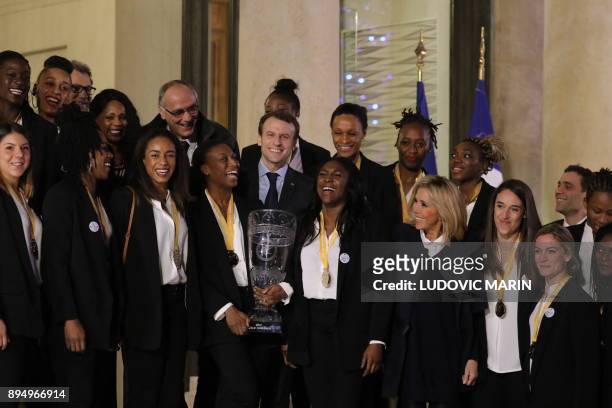French President Emmanuel Macron and his wife Brigitte pose with members of the French womens handball team at The Elysee Palace in Paris on December...