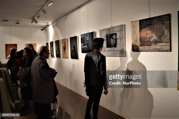 Visitors look at paintings during the opening of the 'Human Creation' Art Exhibition in Ankara, Turkey on December 18, 2017. The exhibition, which is...