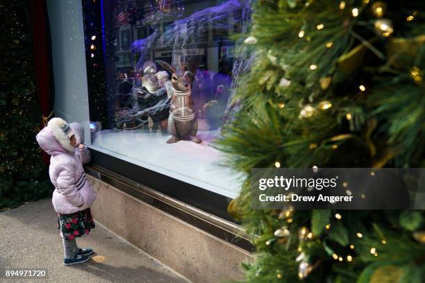 Children view a holiday display in the window of Lord & Taylor in Midtown Manhattan, December 18, 2017 in New York City. The city is decked out in...
