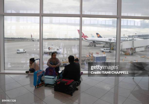 Family waits for their flight at the International terminal the day following a power outage caused by a fire at Hartsfield-Jackson Atlanta...