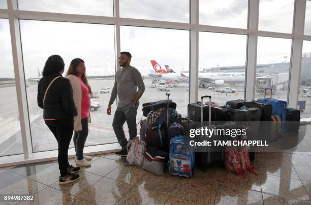 Family waits for their flight at the International terminal the day following a power outage caused by a fire at Hartsfield-Jackson Atlanta...