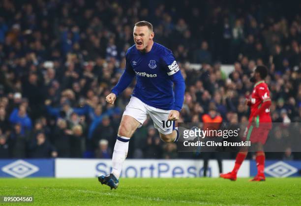 Wayne Rooney of Everton celebrates as he scores their third goal from the penalty spot during the Premier League match between Everton and Swansea...