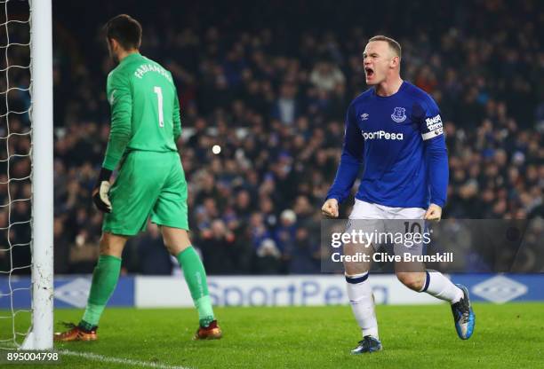 Wayne Rooney of Everton celebrates as he scores their third goal from the penalty spot as Lukasz Fabianski of Swansea City looks dejected during the...