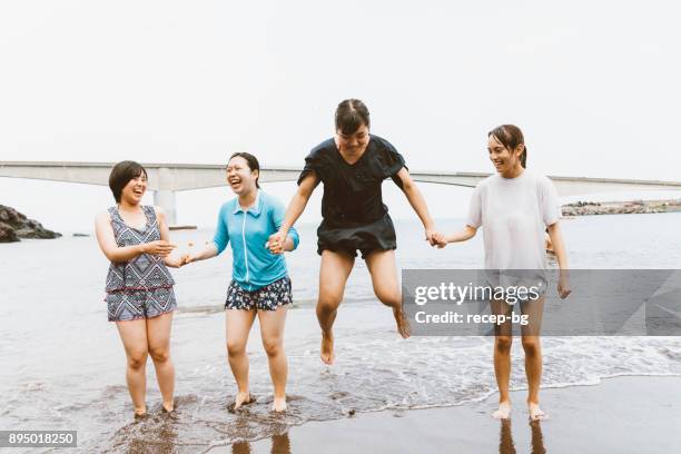 groupe d’amis femmes sautant sur la plage - jeune fille asiatique bord de mer photos et images de collection