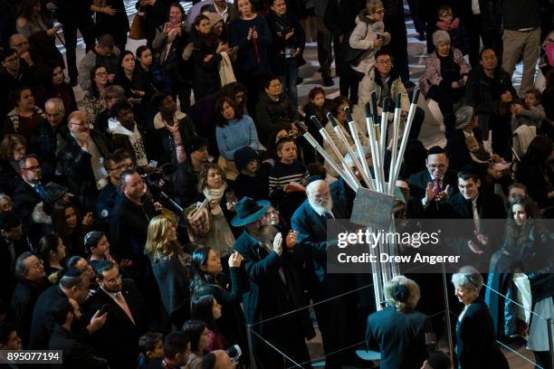 People attend a lighting ceremony for a new Hanukkah menorah that incorporates steel from the destroyed World Trade Center, inside the Oculus World...