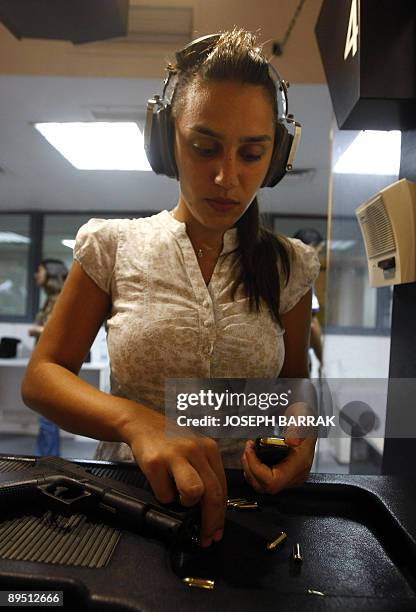 Magnum Shooting Club member Rouba Mourad fills a cartridge magazine as she practices pistol shooting at the Magnum Shooting Club in the Lebanese town...