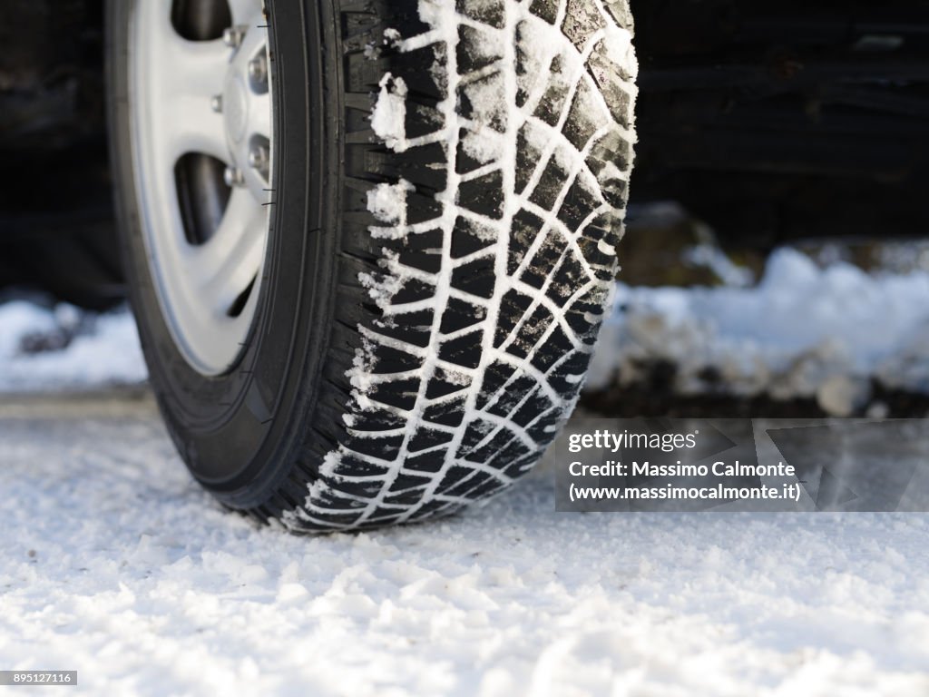 Snow covered tyre on snowy road