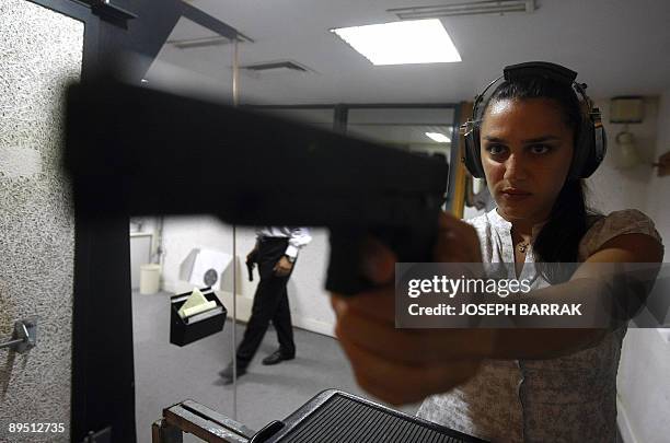 Magnum Shooting Club member Rouba Mourad practices pistol shooting at the Magnum Shooting Club in the Lebanese town of Hadath, east of Beirut on July...