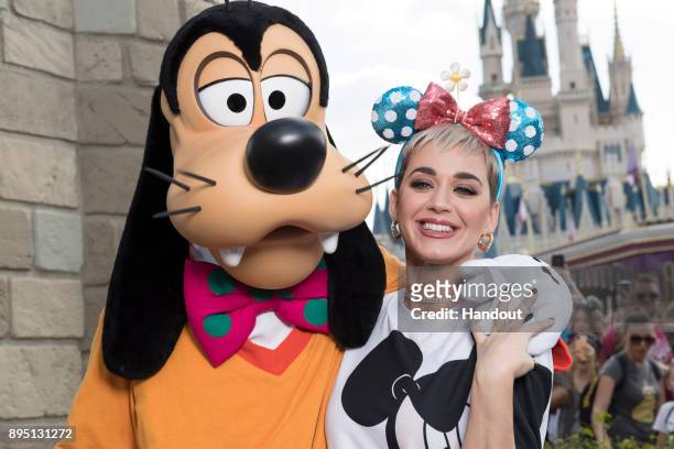 In this handout photo provided by Disney Parks, singer Katy Perry poses with Goofy at the Magic Kingdom Park on December 18, 2017 at Walt Disney...