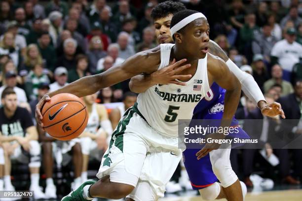 Cassius Winston of the Michigan State Spartans drives around Braxton Bonds of the Houston Baptist Huskies during the second half at the Jack T....
