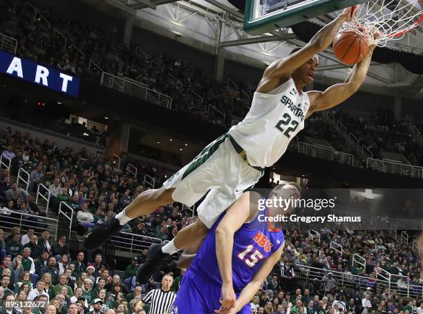 Miles Bridges of the Michigan State Spartans dunks over Edward Hardt of the Houston Baptist Huskies during the first half at the Jack T. Breslin...