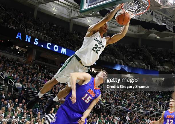 Miles Bridges of the Michigan State Spartans dunks over Edward Hardt of the Houston Baptist Huskies during the first half at the Jack T. Breslin...