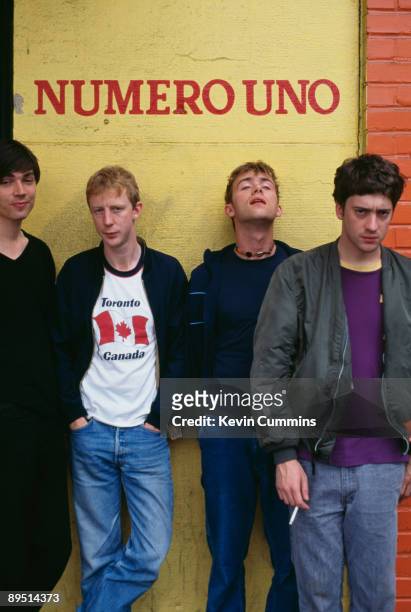 English rock band Blur pose in front of the words 'Numero Uno', circa 1995. From left to right, bassist Alex James, drummer Dave Rowntree, singer...