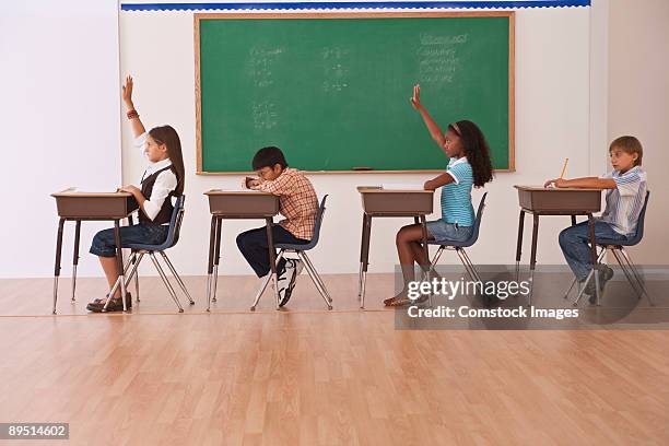 girls raising there hands in classroom - ragazzo new york foto e immagini stock