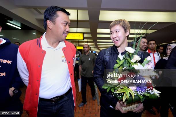 This picture taken on December 18, 2017 shows Indonesia's Minister of Youth and Sport Affairs Imam Nahrawi walking next to badminton player Marcus...