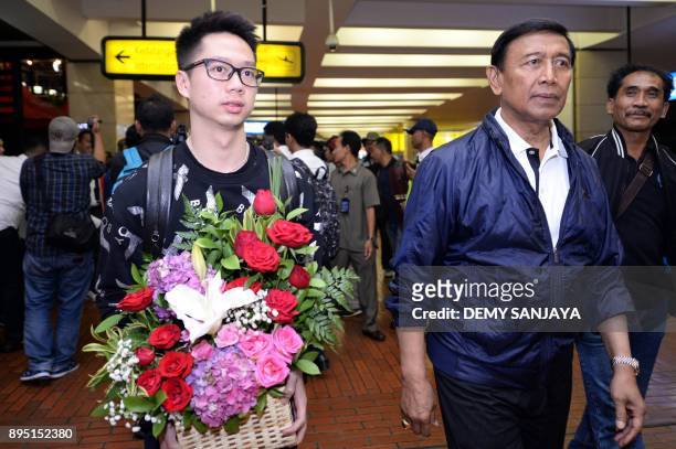 This picture taken on December 18, 2017 shows badminton player Kevin Sanjaya Sukamuljo walking next to Indonesia's coordinating minister for...