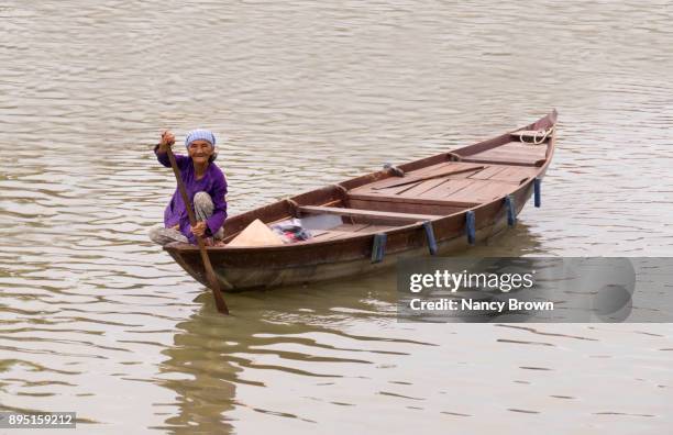 traditional vietnamese woman on boat in hoai river in hoi an in vietnam. - purple bandanna stock pictures, royalty-free photos & images