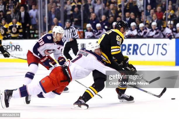 Jack Johnson of the Columbus Blue Jackets is called for hooking against Tim Schaller of the Boston Bruins during the third period at TD Garden on...