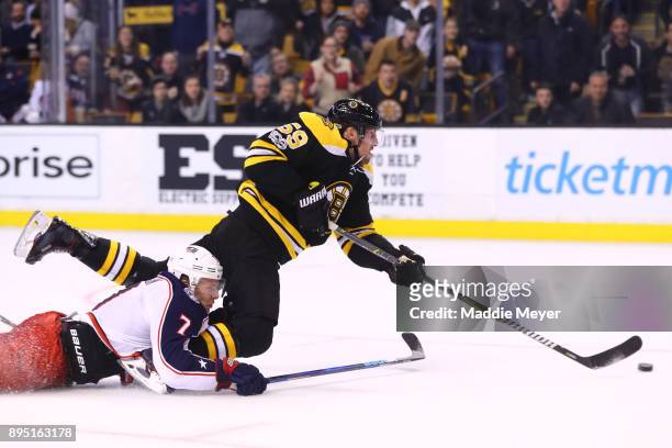 Jack Johnson of the Columbus Blue Jackets is called for hooking against Tim Schaller of the Boston Bruins during the third period at TD Garden on...