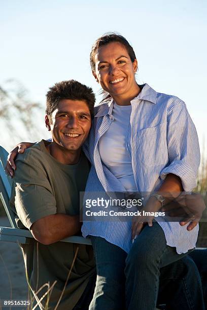 couple sitting in chair on beach - adirondack chair closeup stock pictures, royalty-free photos & images