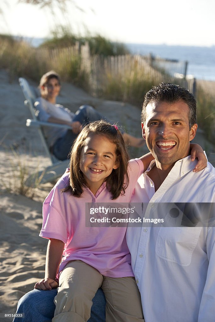 Man and daughter on beach at family picnic