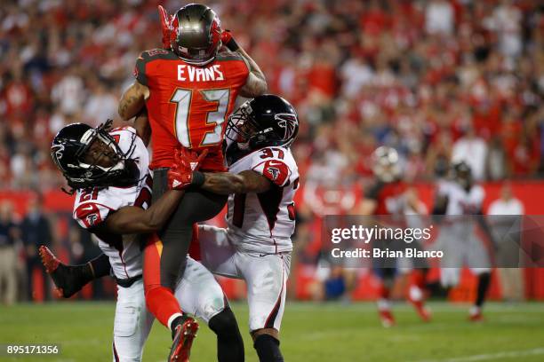 Wide receiver Mike Evans of the Tampa Bay Buccaneers hauls in a 42-yard pass from quarterback Jameis Winston while getting pressure from cornerback...