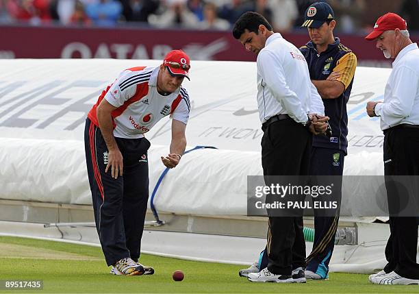 England cricket captain Andrew Strauss rolls a ball across the grass as Australia captain Ricky Ponting and umpires Aleem Da and Rudi Koertzen...