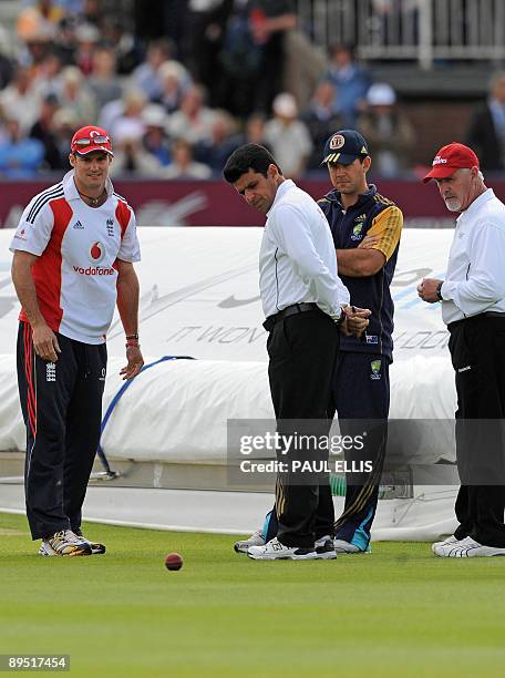 England cricket captain Andrew Strauss rolls a ball across the grass as Australia captain Ricky Ponting and umpires Aleem Da and Rudi Koertzen...