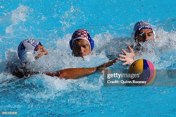 Igor Hinic of Croatia is challenged by Vanja Udovicic and Zivko Gogic of Serbia during the 13th FINA World Championships at the Stadio della...