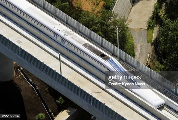 Photo taken in August 2013 shows magnetically levitated train undergoing testing in Tsuru, Yamanashi Prefecture. A maglev train service will start...